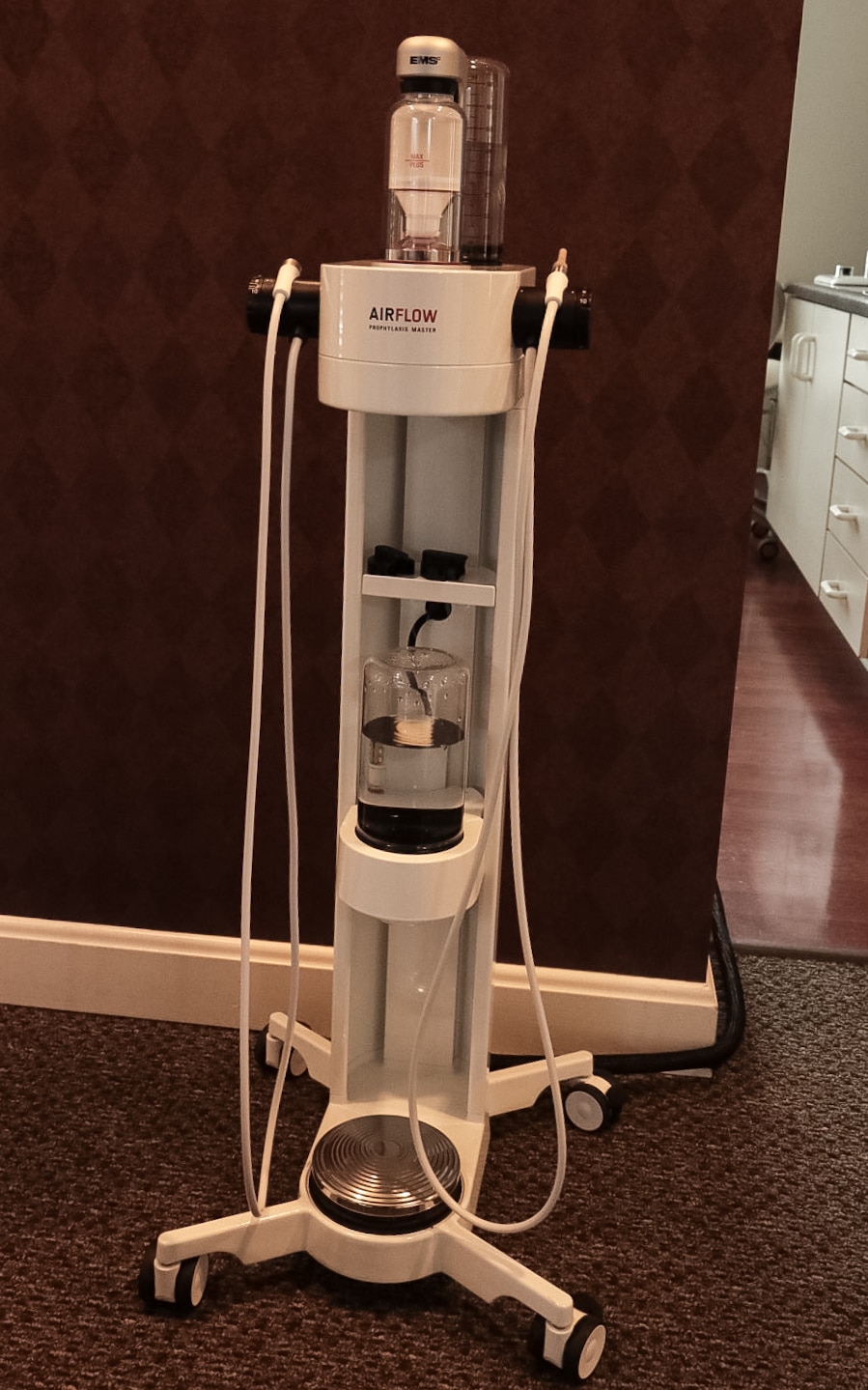 EMS AIRFLOW Prophylaxis Master on its mobile stand with handpieces and water reservoirs