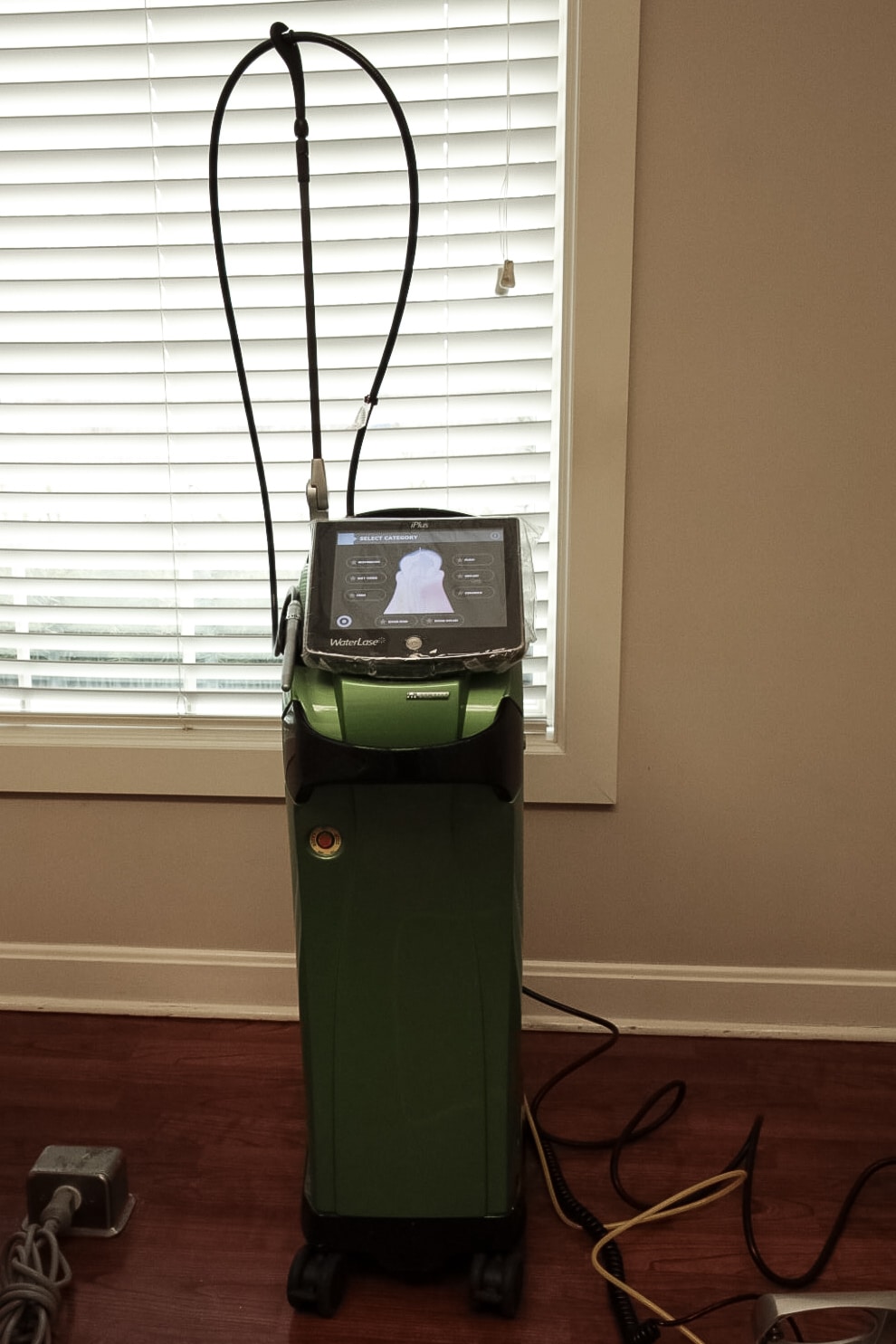 Dental laser system with its fiber-optic delivery arm, in a Fox River Periodontics treatment room